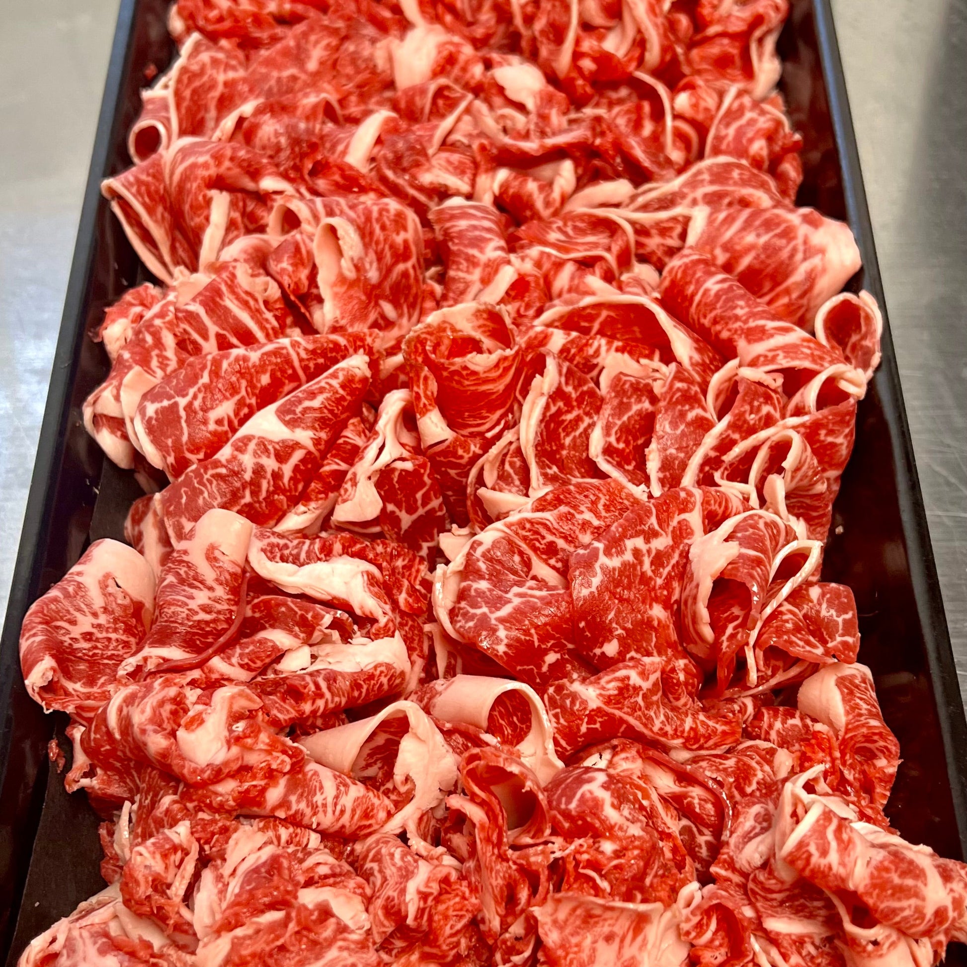 shaved wagyu beef in a butcher tray